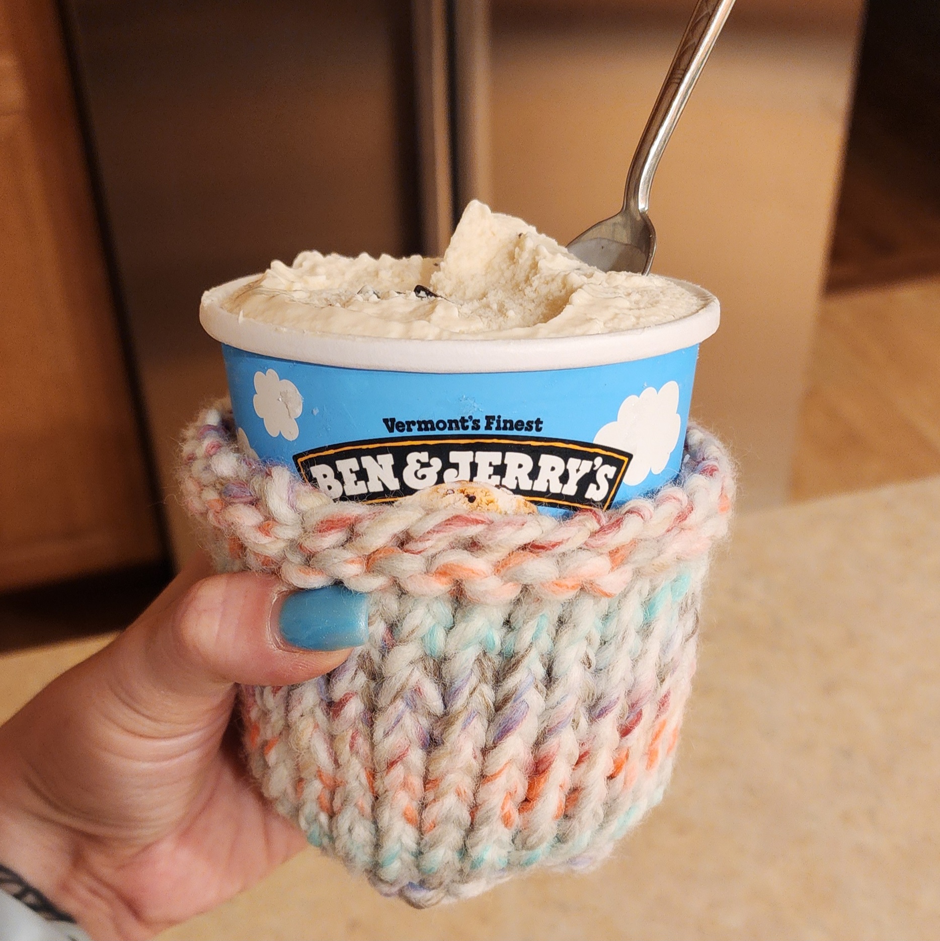 A crochet ice cream cozy placed over a pint sized Ben & Jerry's ice cream container.