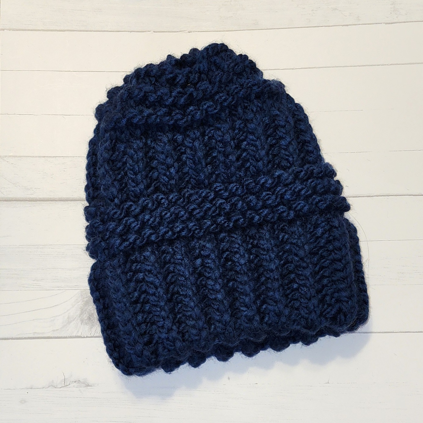 A dark blue crochet beanie handmade by Bella Faith Designs.